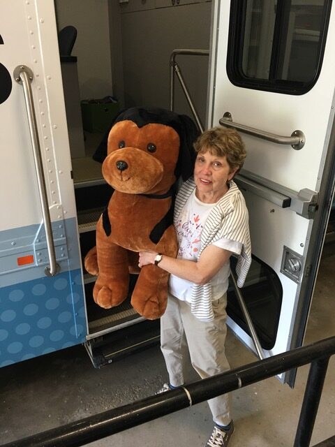 Photo of the author, Pamela Cameron, with a stuffed dog to represent the dog, Sport.